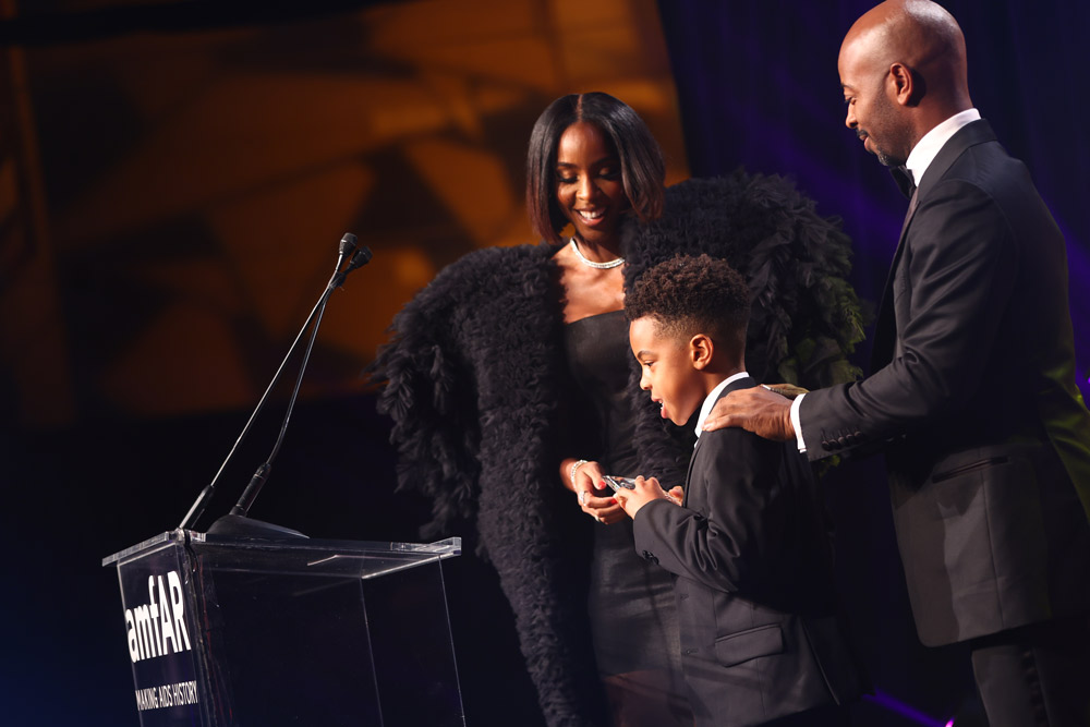 Kelly Rowland accepts the amfAR Award of Courage with her husband Tim Weatherspoon and son Titan (photo: Getty Images for amfAR)