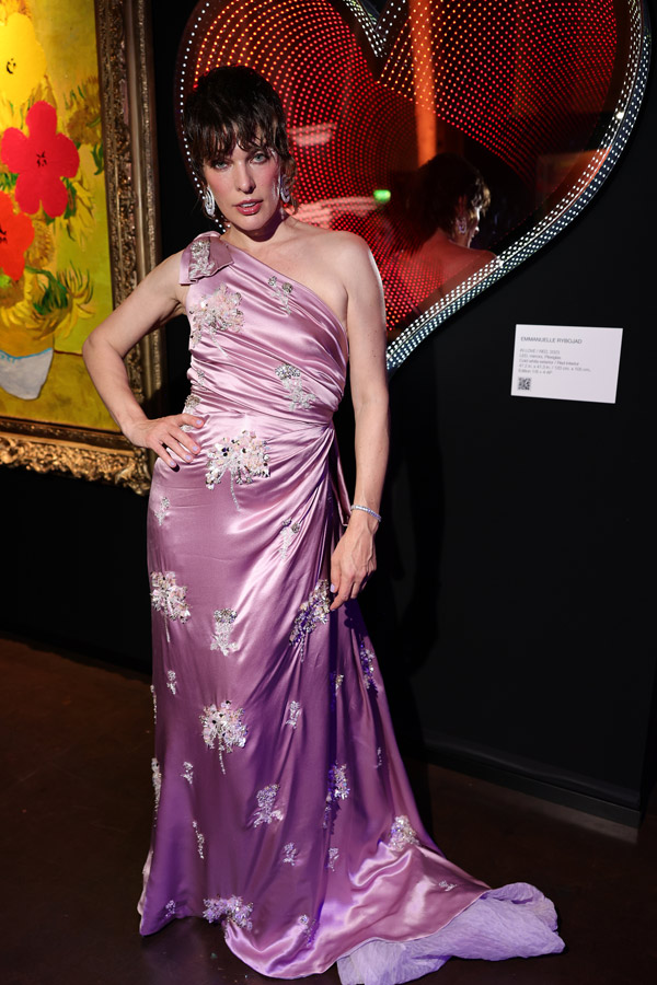 Longtime amfAR supporter Milla Jovovich in front of some of the art up for auction. Photo by Getty Images