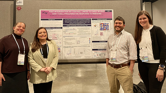 Demi Sandel, a fourth-year PhD student in the UCSF Biomedical Sciences program, presenting her poster to a crowd of intent listeners.