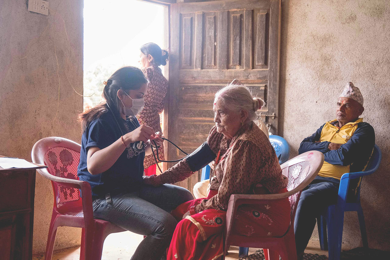 Healthcare worker testing elderly woman for HIV in a rural setting.