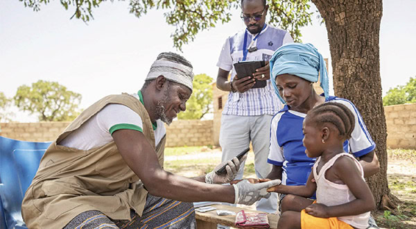 AmfAR community outreach with healthcare worker and children outdoors.