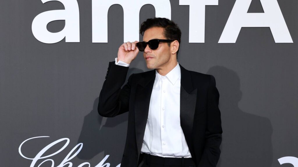Rami Malek at the amfAR Gala Cannes 2026, wearing a black tuxedo.