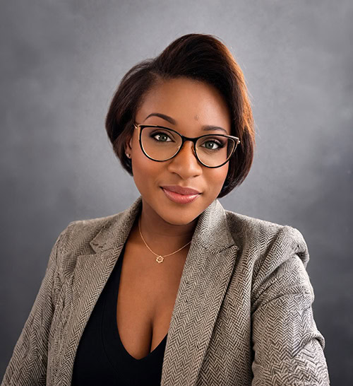 Portrait of a professional woman wearing glasses and a blazer.